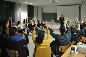 students sitting in a circle applauding in sign language with hands in the air